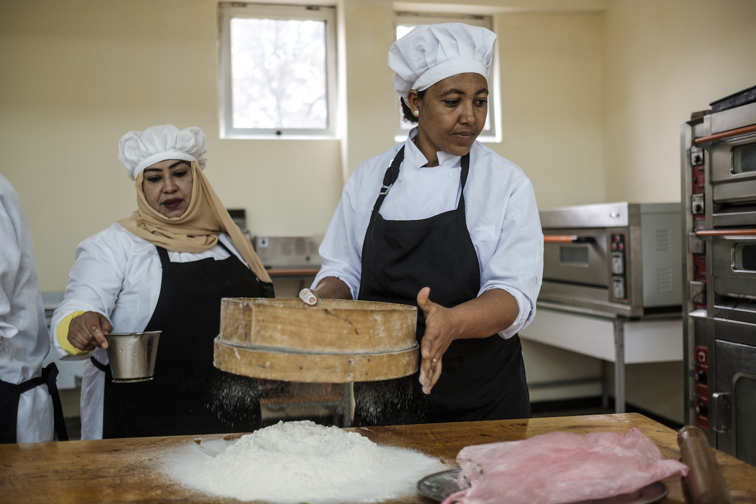 Refugee workers baking in a kitchen