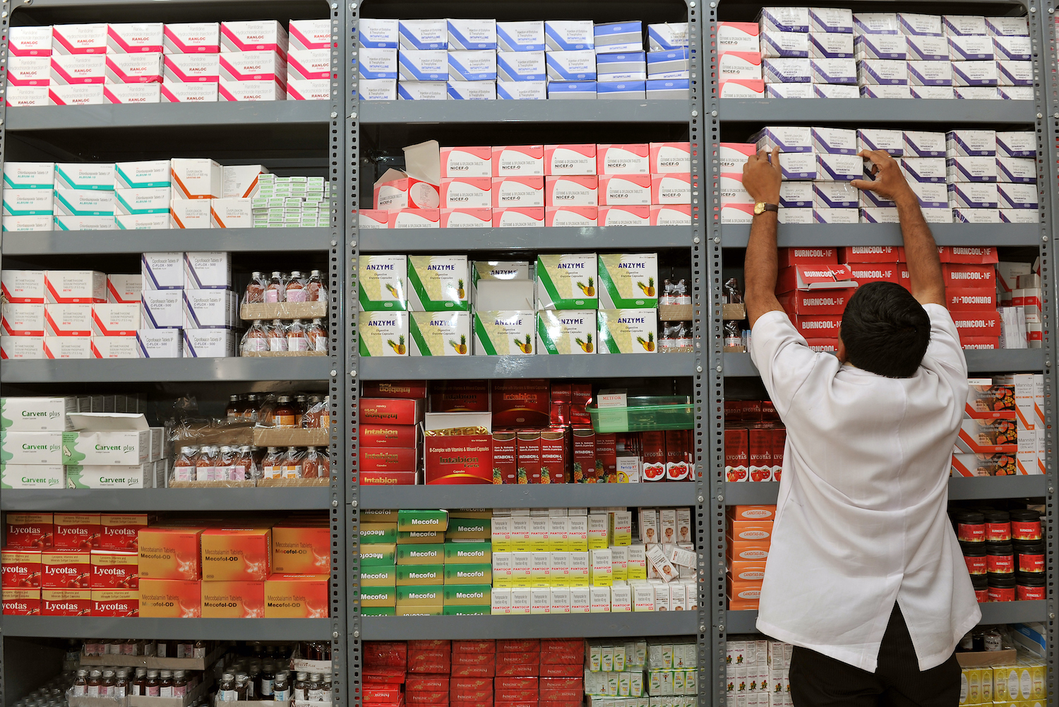 An Indian  pharmacist pulls out a box of medicines from a shelf at a Generic Drug Store at the Victoria Hospital in Bangalore on June 28, 2012. The Generic Drug Store which was opened in Bangalore recently by the medical education department in association with the Karnataka State Cooperative Consumer Federation sells branded generic drugs which are priced less than 50 percent of the Maximum Retail Price (MRP). Estimates by Dolat Capital show that the US generic market, currently estimated at USD350 billion