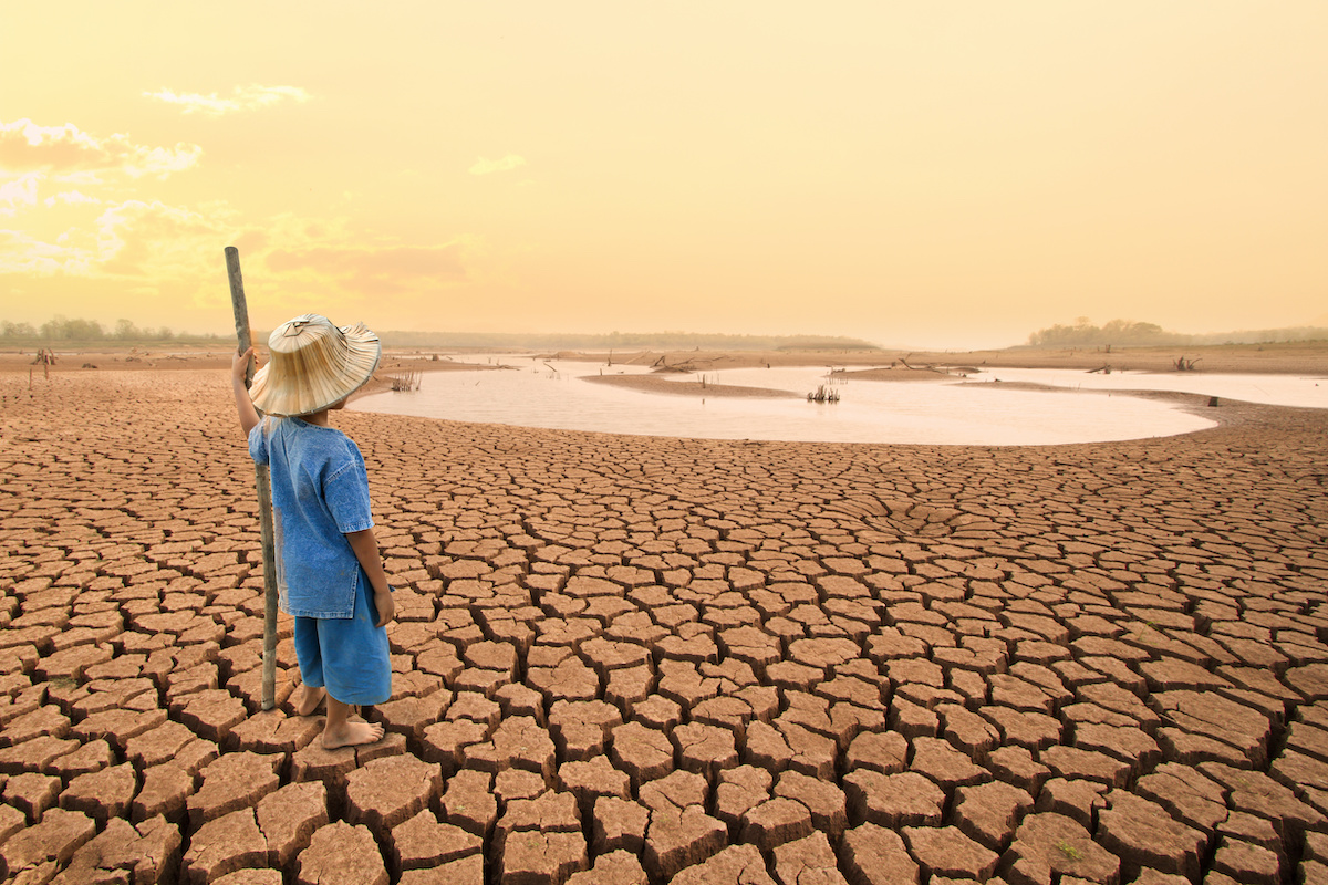 Climate change and World environmental concept. Children looking at drying river after Drought impact on summer.