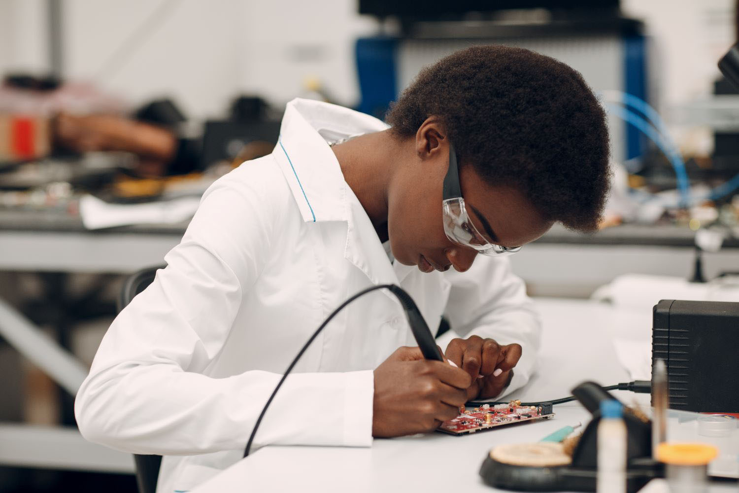 Scientist woman working in laboratory with soldering iron.