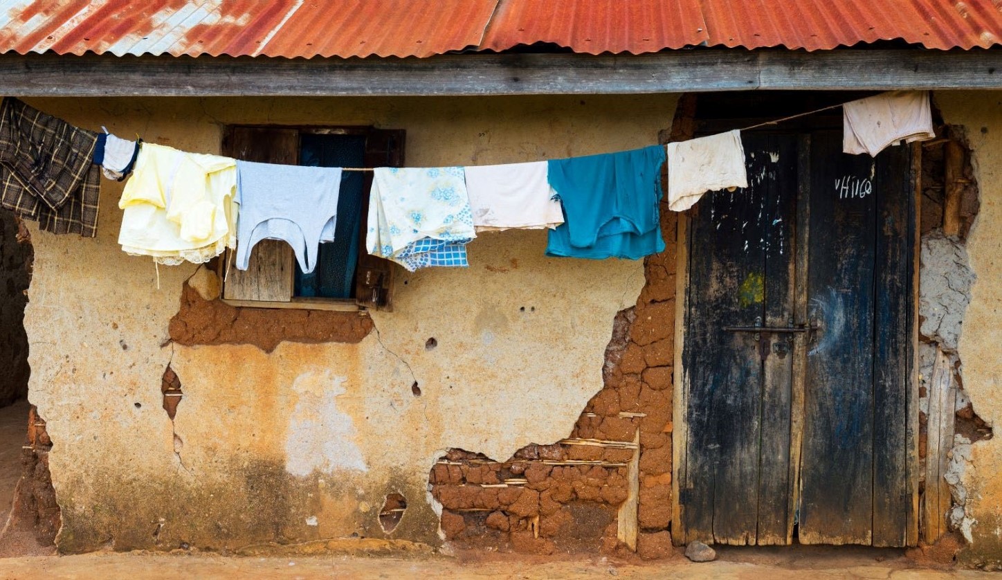Mud brick home with clothes drying on clothes line, Uganda Africa