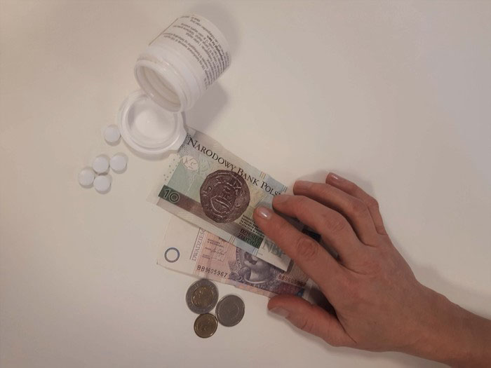 Bottle of pills next to Polish money