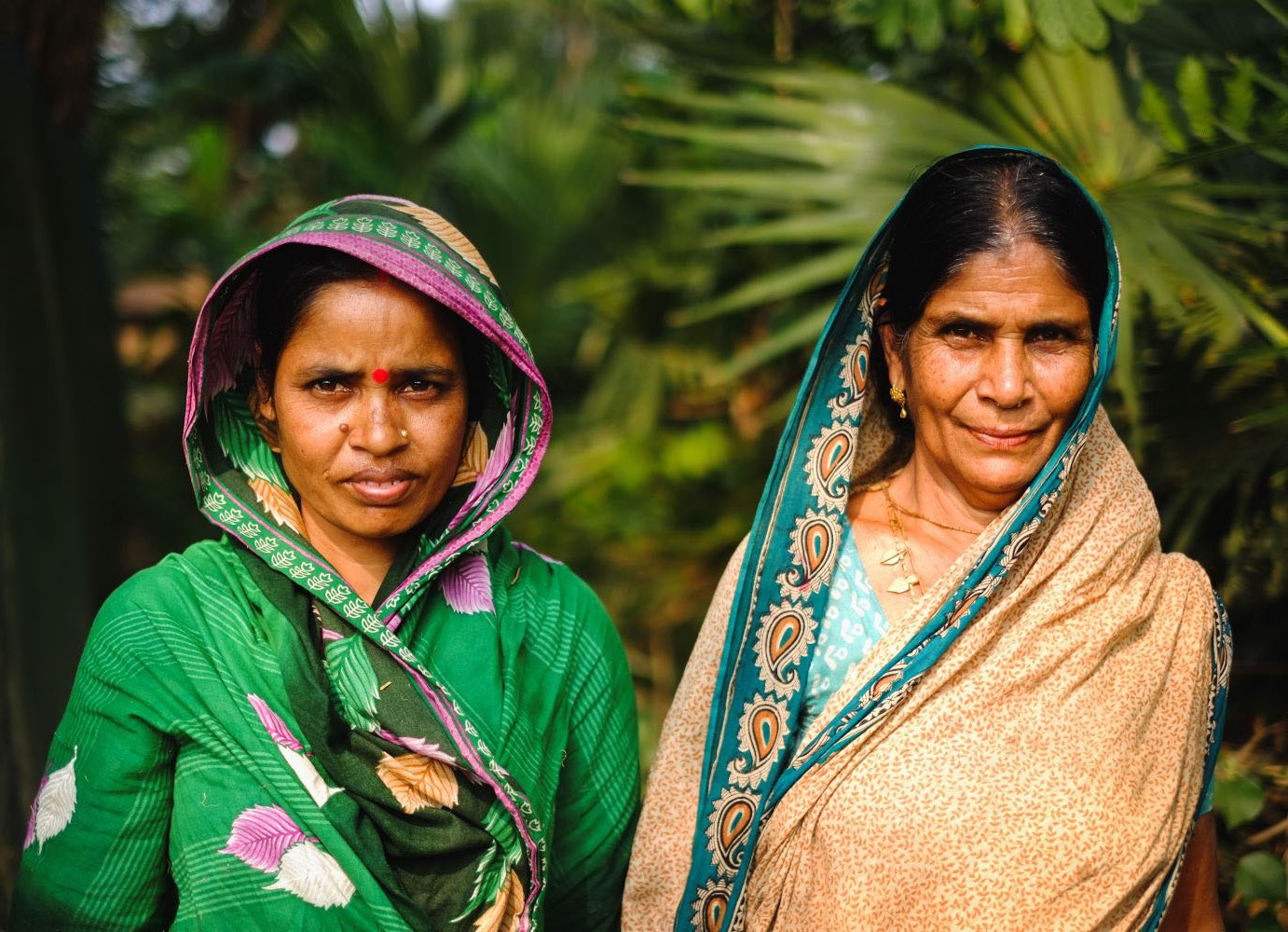 Elderly mother with her daughter standing together in a forest