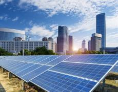 An image showing solar panels and a city skyline in the background.