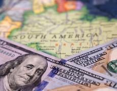 Two US$100 bills on top of a map of Latin America