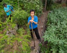 Tadakorn Suttiporn, a member of HomeNet Thailand, tends to the community-run garden in Thailand.