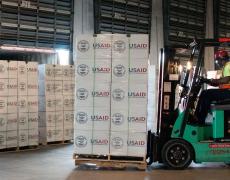 A forklift moves pallets of USAID supplies. Photo by Lance Cheung/USDA.
