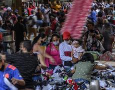 People walk around as street vendors interact with clients as they shop for Christmas season amid the COVID-19 pandemic in Medellin.
