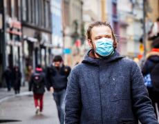 A man in the street wearing a medical mask. Adobe Stock